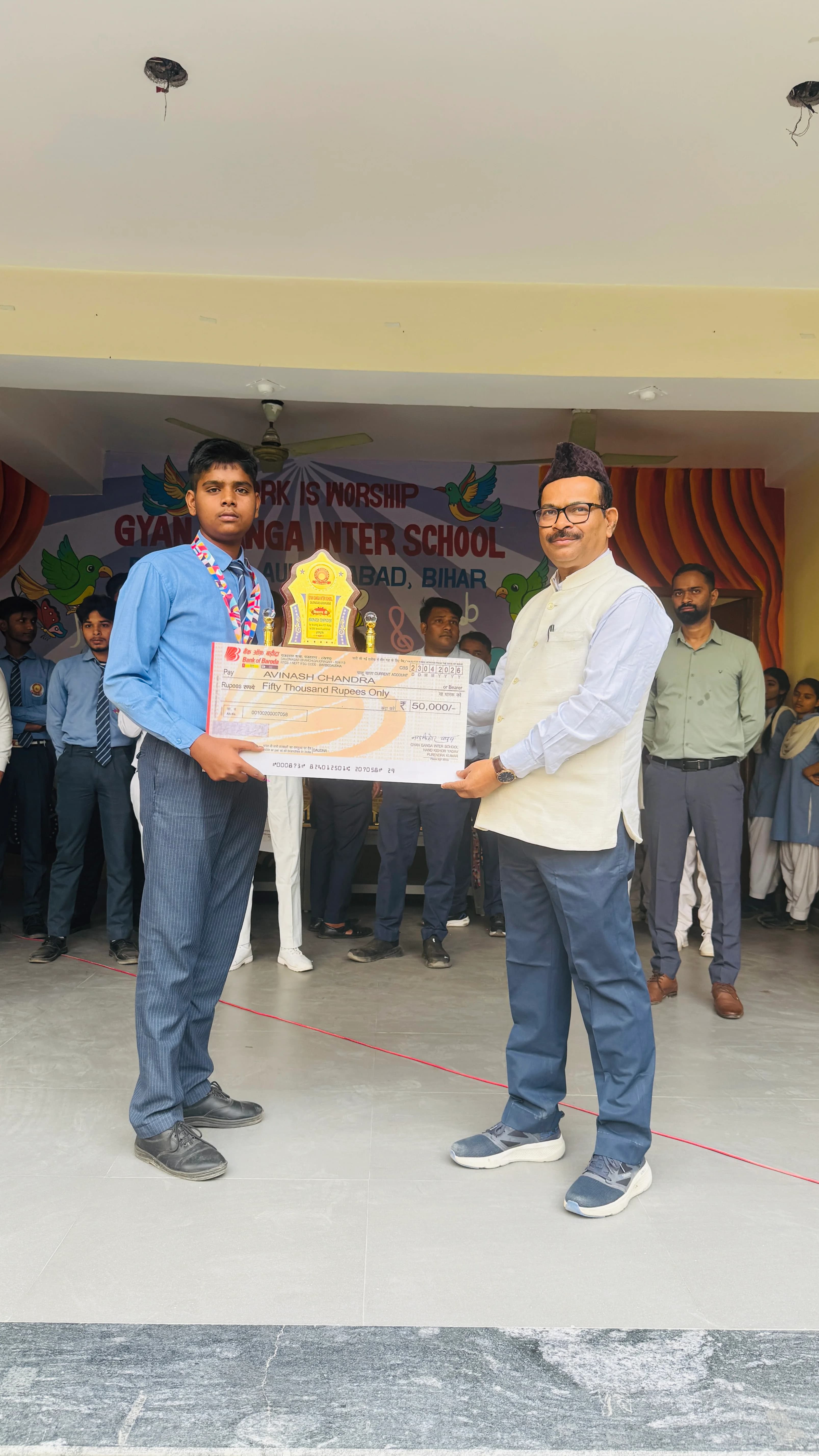 Avinash Chandra receiving ₹50,000 cash cheque